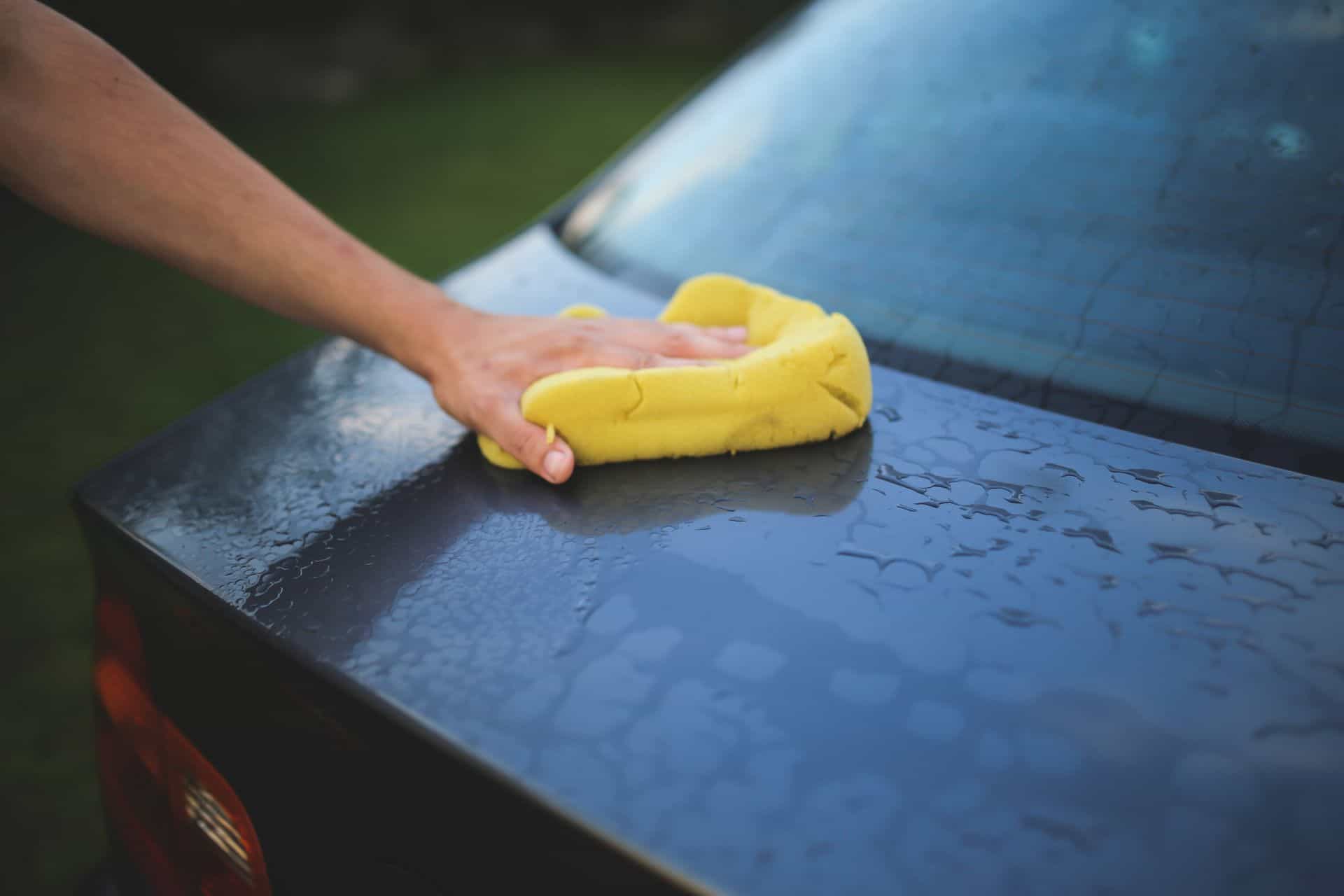 Een auto wordt gereinigd met een spons
